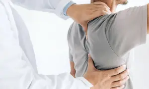 Läkare undersöker en patient med ont skulderblad som begränsar andas.