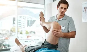 Fysioterapeut undersöker en patients vadmuskel, möjligen för att identifiera triggerpunkter vaden.