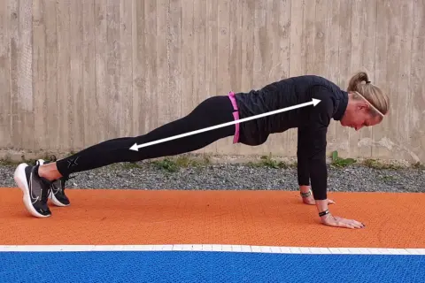 En kvinna i plankposition, redo för mountain climbers.