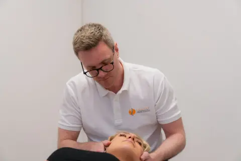 Kiropraktorn justerar nacken på en patient. Han fokuserar på området kring c4 c5 för att lindra spänningar.