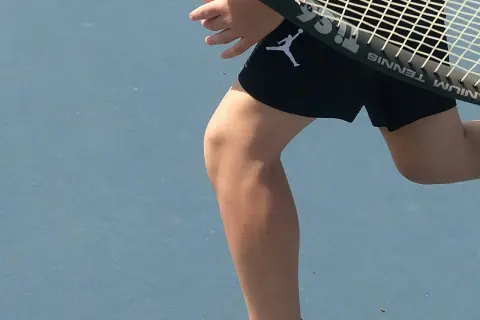Tennisspelare med ont i ljumsken tips. En person i svarta shorts med Jumpman-logga på en blå tennisbana.