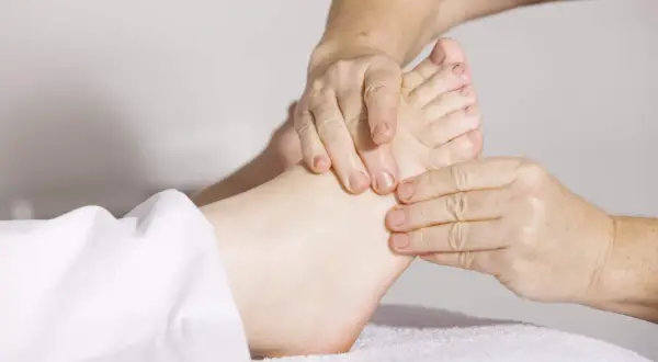 Close-up of hands massaging a foot.