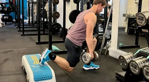 Man utför bulgarian split squat med hantlar för att träna framför allt framsida lår och rumpa.