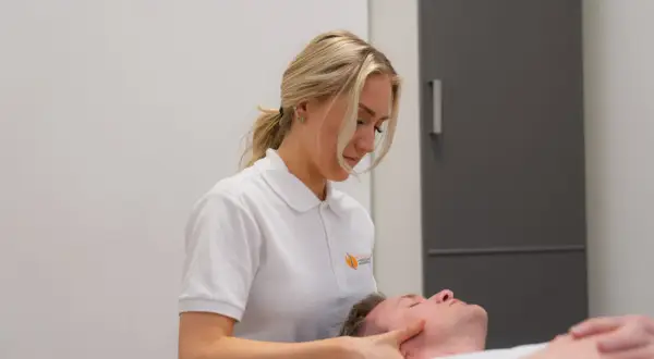 En kiropraktor undersöker en patient med artros i nacken och yrsel.