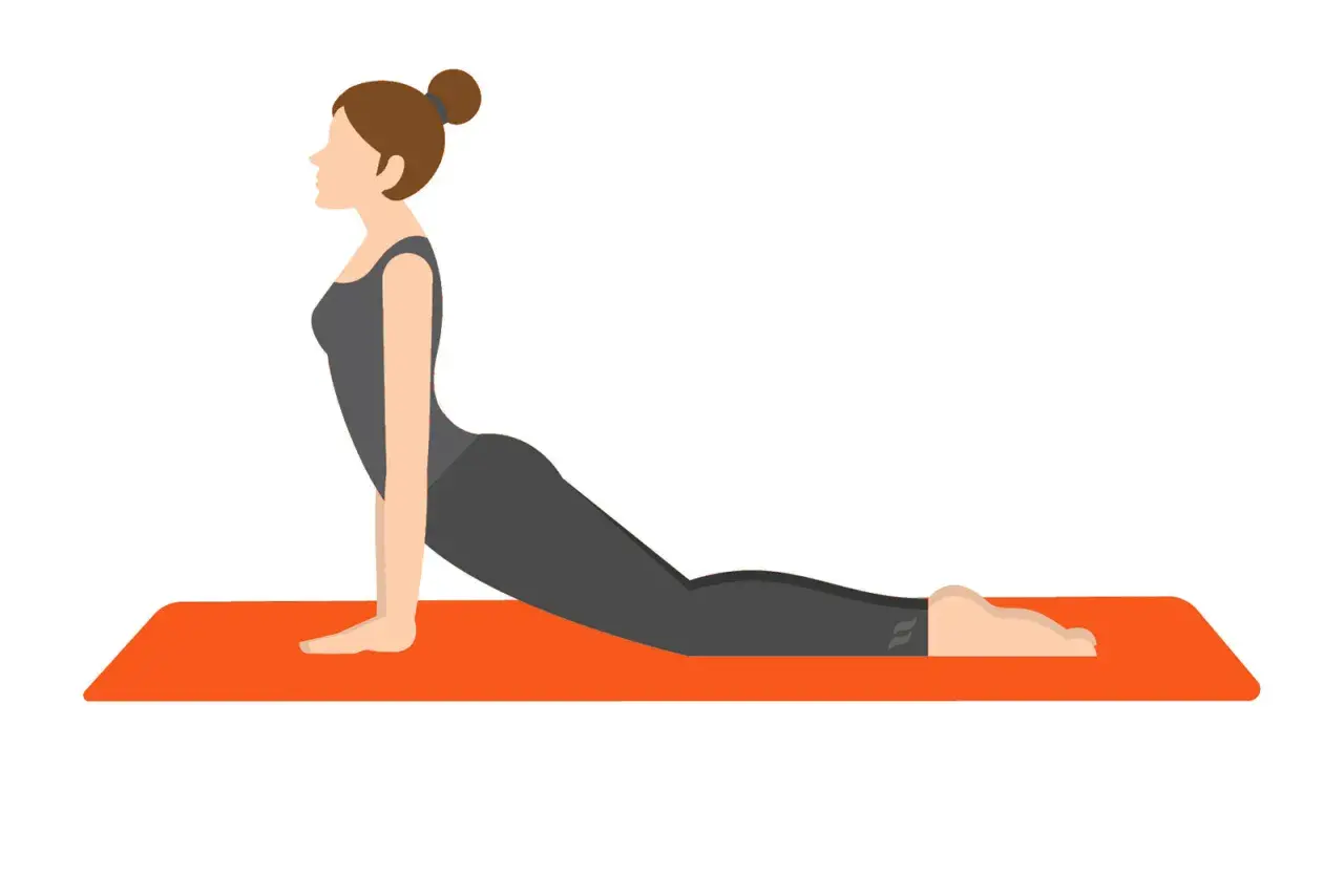 Kvinna i mörk träningsoverall gör en cobra-ställning på en orange yogamatta för att stretcha rygg.