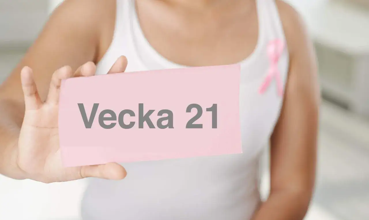 En person h&aring;ller upp en rosa lapp med texten 