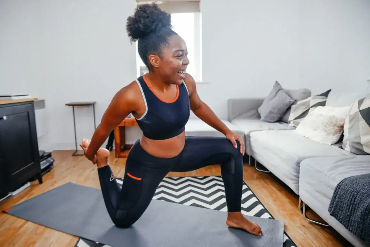 Kvinna stretchar på yogamatta, redo att gå ner i spagat på 4 veckor.